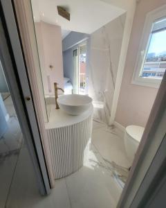 een witte badkamer met een wastafel en een toilet bij Sea Front Madame blue 4-star two-room in ecological health design in Roquebrune-Cap-Martin