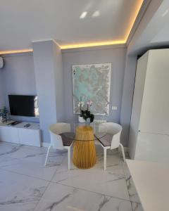 een woonkamer met een tafel en twee stoelen bij Sea Front Madame blue 4-star two-room in ecological health design in Roquebrune-Cap-Martin