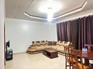 ein Wohnzimmer mit Sofa und Tisch in der Unterkunft EASY KIGALI STAY Apartment in Kigali