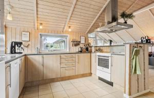 a large kitchen with wooden cabinets and a window at Gorgeous Home In Ebeltoft With Sauna in Ebeltoft