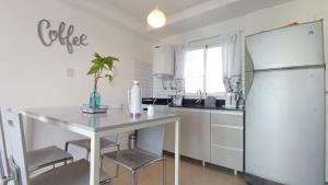 a kitchen with a white refrigerator and a table at Apart Alameda in Paraná