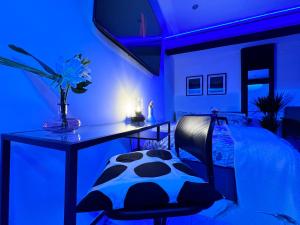 a blue room with a bed and a table with a vase of flowers at Gorgeous Holiday Home 5 minutes from Central London in London