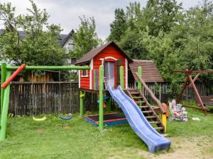 une aire de jeux avec un toboggan et une maison de jeux dans l'établissement U Ziutka, à Jurgów