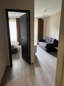 an open door to a living room with a couch at Bakuriani Crystal Loft Apt in Bakuriani +14 photos