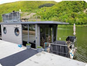 a small house on a boat in the water at Hausboot auf der Mosel in Pölich