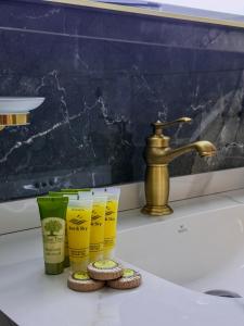a sink with three cups and a faucet and cookies at Aphrodite Apartment in Athens +20 photos