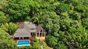an aerial view of a house in the middle of a forest at Relax At This Hillside Retreat That Overlooks The Lush Forest And The Caribbean, in West End