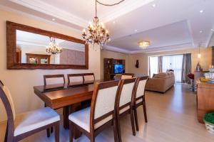 Un comedor y una sala de estar con mesa y sillas. en Rosa Residencial Celita Pascoal, en Gramado