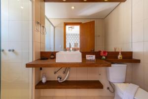 Un baño con lavabo, espejo e inodoro. en Rosa Residencial Celita Pascoal, en Gramado 30 fotos más