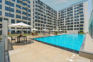 une grande piscine en face d'un grand bâtiment dans l'établissement Chic Liva 1br Family-friendly Great Amenities, à Nadd Shubayḩ