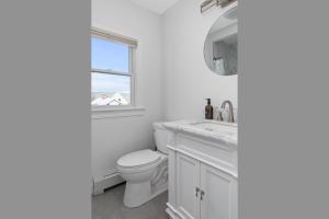 a white bathroom with a toilet and a window at Downtown Charming Retreat Newport in Newport +25 photos