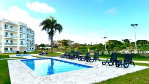 a group of chairs sitting next to a swimming pool at Rheia Properties - SANTA FE in Sosúa