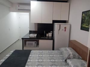 a small kitchen with a refrigerator and a counter at Westfit Mossoró conforto e praticidade para duas pessoas na melhor localização de Mossoró in Mossoró +2 photos