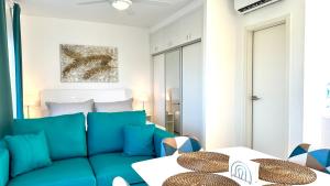 a living room with a blue couch and a bed at Rheia Properties - SANTA FE in Sosúa