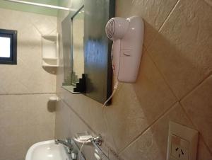 un sèche-cheveux est accroché au mur d'une salle de bain dans l'établissement Casa Boreal dptos estilo casa, à Puerto Madryn