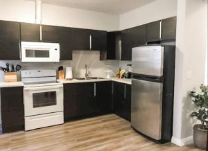 a kitchen with black cabinets and a stainless steel refrigerator at Convention close by 2BR Suite Free Parking in San Diego