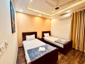 a room with two beds and a ceiling at 2 Bedroom Cozy Apartment by Lux Haven Stays in Lahore