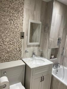 a bathroom with a sink and a toilet and a tub at Central Woking in Horsell