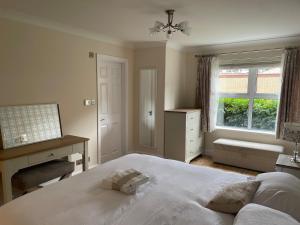 a bedroom with a bed and a desk and a window at Central Woking in Horsell