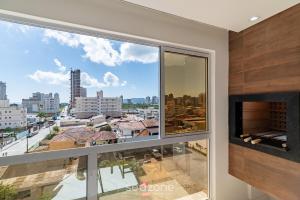 a large window with a view of a city at CII - Apartamentos a 900m da Praia em Porto Belo in Perequê