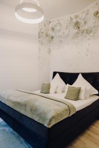 a bedroom with a bed with a black headboard and pillows at Charmanter Altbau in City Nähe in Osnabrück