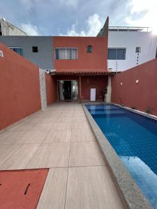 a house with a swimming pool next to a building at Temporada em Jauá in Camaçari