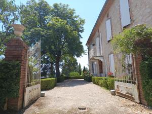 an entrance to a brick house with a wrought iron gate at La chambre de Marin in Lombers