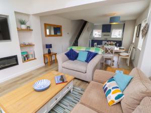 a living room with a couch and a table at Lavender Cottage in Chathill