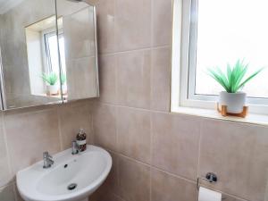 a bathroom with a sink and a mirror at Lavender Cottage in Chathill +20 photos