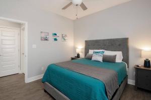 a bedroom with a large bed with a blue blanket at Blue Water Escape in Bolivar Peninsula