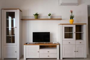 a room with a desk with a tv and a cabinet at Adriatic Escape -Modern Sea View Apartment,Special Summer Deal in Pržno