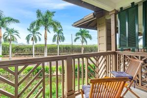 a porch with two chairs and palm trees at Last Min Prices! Kiahuna Escape - AC, Pool, Golf in Koloa