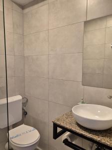 a bathroom with a white toilet and a sink at ALYA Sea Escape Costinesti - parcare gratuita in Costinesti