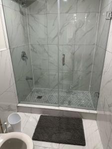 a shower with a glass door in a bathroom at Cozy 1 Bedroom Apartment in Brampton