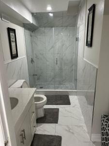 a bathroom with a shower and a toilet and a sink at Cozy 1 Bedroom Apartment in Brampton