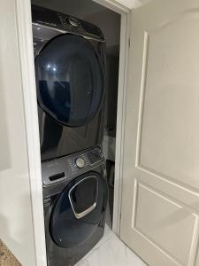 a washer and dryer in a room next to a door at Cozy 1 Bedroom Apartment in Brampton