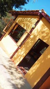 a yellow building with a door and a window at Chalé Inhambu Tiradentes in Tiradentes