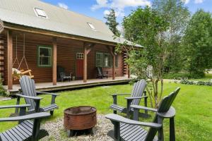 two chairs and a barrel in front of a cabin at Charming Vermont Log Cabin in Cambridge