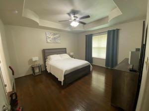a bedroom with a bed and a ceiling fan at Charming 3-Bedroom Retreat in Prime Neighborhood in Brownsville