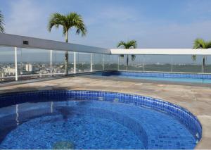 a swimming pool on the roof of a building at Flat Aconchegante no Millenium Hotel in Manaus