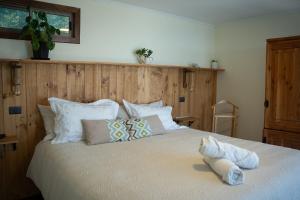 a bedroom with a large bed with white sheets and pillows at Viento Sur Pichilemu Lodges Cama King con Calientacamas in Pichilemu