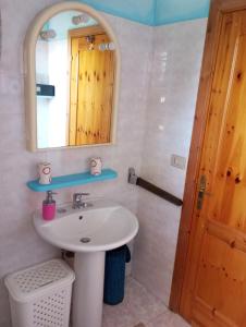 un baño con lavabo y espejo en Casa vacanze Wally a Posada, Sardegna, en Posada