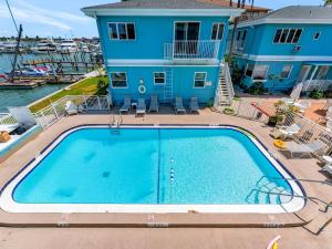 an image of a swimming pool in front of a house at Sunlit Condo Heated Pool across from Beach in Clearwater Beach