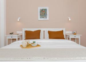 białe łóżko z tacą, na której stoją dwa kubki w obiekcie Livinn Acropolis View LV w Atenach