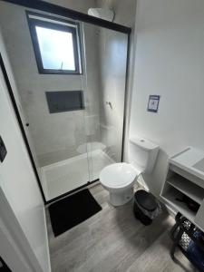 a white bathroom with a shower and a toilet at São Roque Chalés in São Roque +21 photos