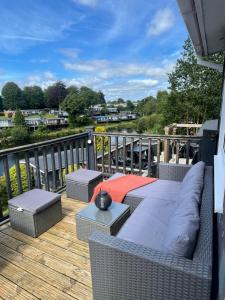 a patio with a couch and tables on a deck at Summit Rest in Caeathro