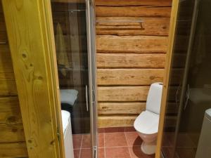 ein Badezimmer mit Toilette und einer Holzwand in der Unterkunft Vana-Paradiisi in Uulu + 21 Fotos