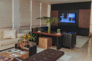 a living room with a couch and a tv at Hotel BR 364 in Cacoal