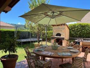 een terrastafel met parasol en pizzaoven bij Beautiful villa with pool in Provence in Sisteron