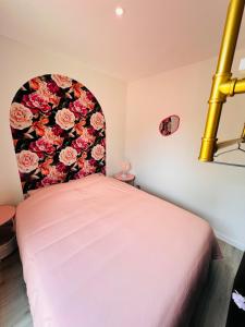 a bedroom with a bed with a floral headboard at La Fleur au cœur de la nature in Rosselange